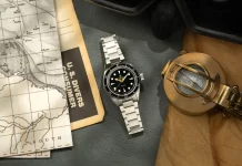 A Lorier visszahozza az Astrát, Falcont, Neptune-t és Hyperiont Lorier Neptune dive watch flatlay on grey leather surface with vintage nautical depth chart, U.S. Divers consumer catalog, and open antique brass surveying compass on aged craft paper.