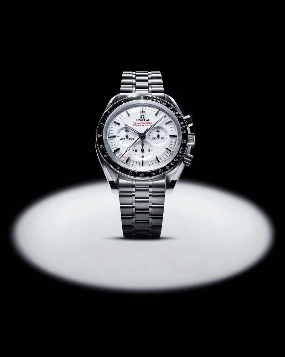 Melyik Speedmaster az igazi Moonwatch? Az Omega referenciáinak áttekintése Fehér számlapos OMEGA Speedmaster Moonwatch acélcsaton, fekete háttér előtt