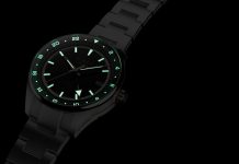 Timex Atelier GMT Première M1a: 38 milliméterben tér vissza a márka GMT-je Timex Atelier GMT Première M1a watch glowing in the dark with illuminated hour markers, hands, and 24-hour scale.