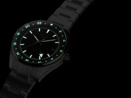 Timex Atelier GMT Première M1a: 38 milliméterben tér vissza a márka GMT-je Timex Atelier GMT Première M1a watch glowing in the dark with illuminated hour markers, hands, and 24-hour scale.