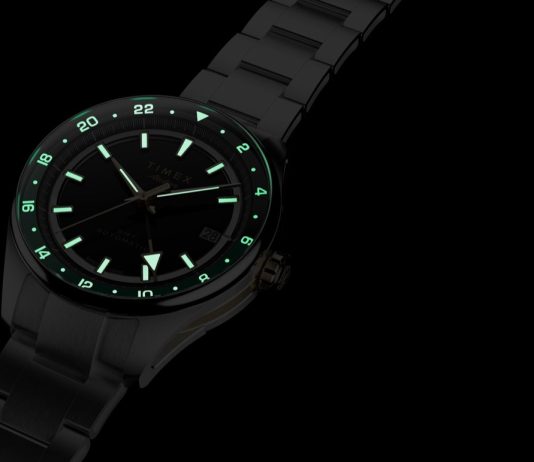 Timex Atelier GMT Première M1a: 38 milliméterben tér vissza a márka GMT-je Timex Atelier GMT Première M1a watch glowing in the dark with illuminated hour markers, hands, and 24-hour scale.