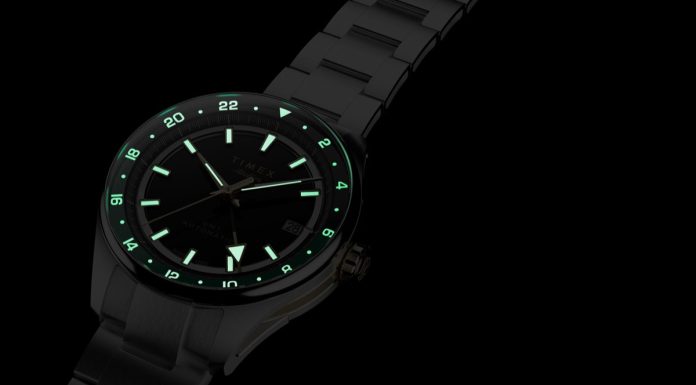 Timex Atelier GMT Première M1a: 38 milliméterben tér vissza a márka GMT-je Timex Atelier GMT Première M1a watch glowing in the dark with illuminated hour markers, hands, and 24-hour scale.