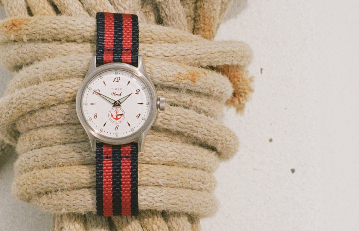 Elérhető a NOAH x Timex MK1 Anchor Gift Set: két textilszíjjal jön a 36 mm-es MK1 NOAH x Timex MK1 Anchor watch with a white dial and red-and-navy striped fabric strap resting on coiled nautical rope.