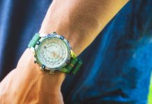 Timex túraóra-útmutató: mi számít tényleg a terepen, és mi csak funkciólista A Timex Expedition Tide-Temp-Compass watch with a cream dial, stainless-steel case, and green silicone strap worn on the wrist outdoors. Features luminous hands, orange tide indicators, and compass bezel accents.