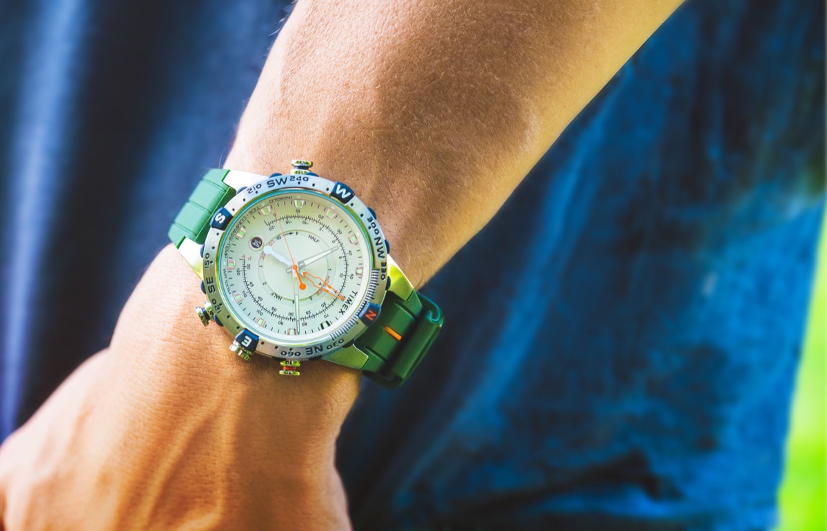 Timex túraóra-útmutató: mi számít tényleg a terepen, és mi csak funkciólista A Timex Expedition Tide-Temp-Compass watch with a cream dial, stainless-steel case, and green silicone strap worn on the wrist outdoors. Features luminous hands, orange tide indicators, and compass bezel accents.