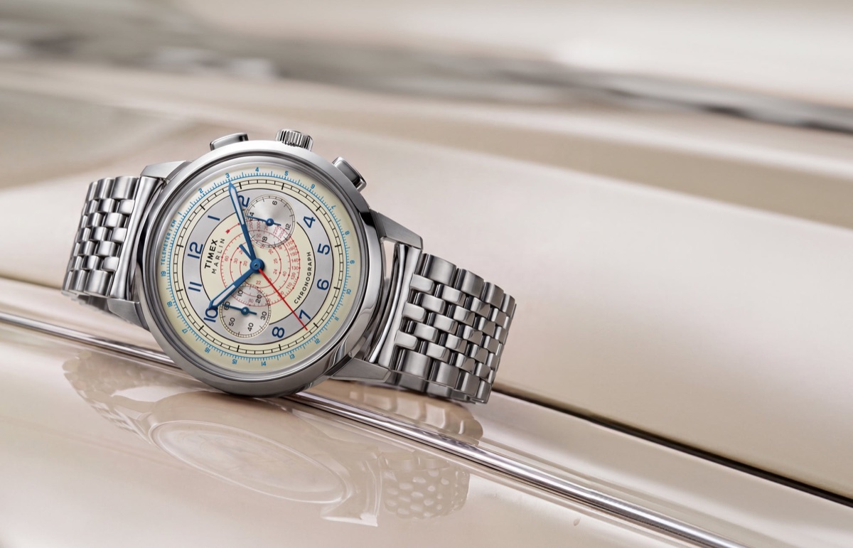 Marlin® Neo Classic Chronograph with a cream dial, blue hands, red markings, and stainless-steel bracelet resting on a cream-colored car.