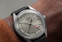 Timex Marlin Jet Titanium Automatic GMT: retrofuturisztikus tok, titánból Close-up of the Marlin® Jet Titanium Automatic GMT on the wrist, featuring a cream dial, red GMT hand, date window, and black leather strap.