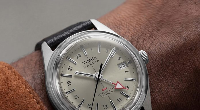 Timex Marlin Jet Titanium Automatic GMT: retrofuturisztikus tok, titánból Close-up of the Marlin® Jet Titanium Automatic GMT on the wrist, featuring a cream dial, red GMT hand, date window, and black leather strap.