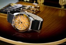 Timex x Fender: három órával ünneplik a Telecaster évfordulóját Fender x Timex Automatic watch with a silver-tone case, amber wood-grain dial, black-and-gold bezel, and black leather strap displayed on a Fender guitar.