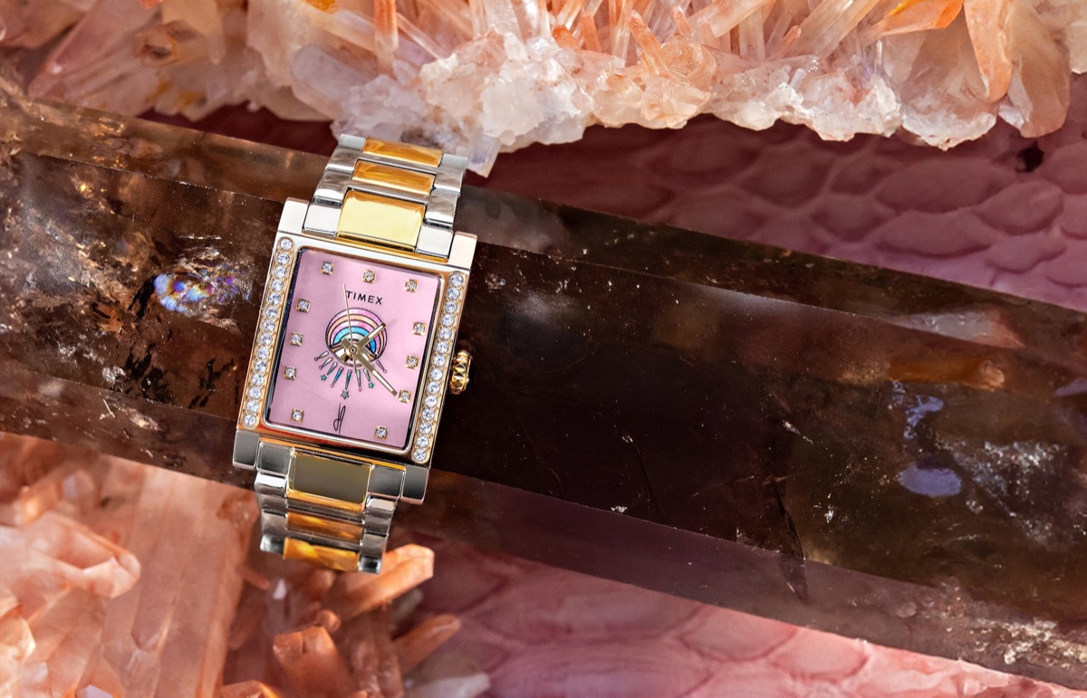 Timex és Jacquie Aiche közös órája: az Éclat kollekció két ékszerszerű időmérőt hoz Timex x Jacquie Aiche Éclat two-tone watch with a pink dial, crystal accents, and eye motif among pink crystals.