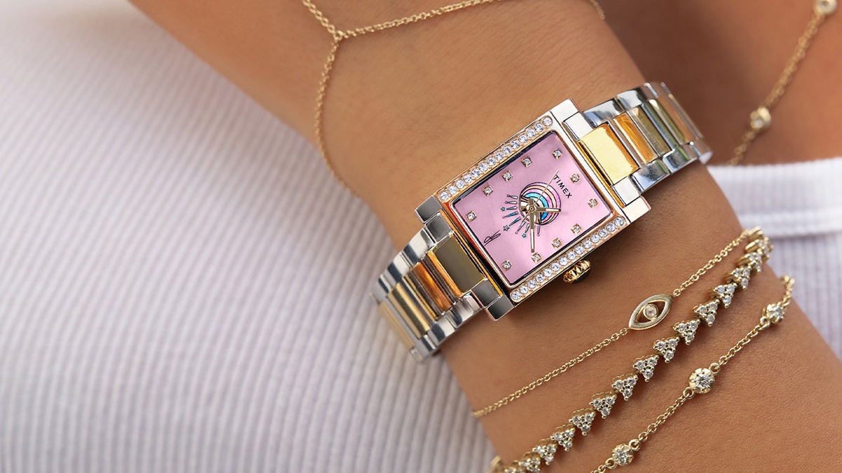 Timex és Jacquie Aiche közös órája: az Éclat kollekció két ékszerszerű időmérőt hoz Timex x Jacquie Aiche Éclat two-tone watch worn alongside layered gold and diamond bracelets.
