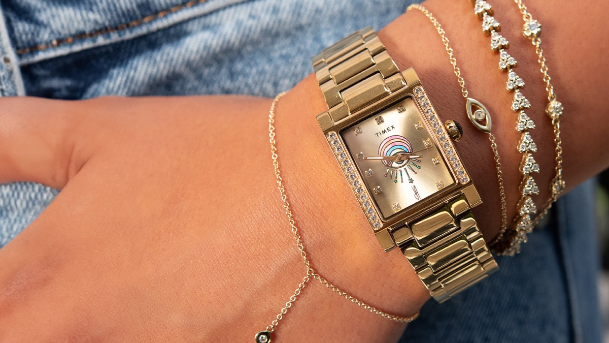 Timex és Jacquie Aiche közös órája: az Éclat kollekció két ékszerszerű időmérőt hoz Gold-tone Timex x Jacquie Aiche Éclat watch worn with layered gold and crystal bracelets.