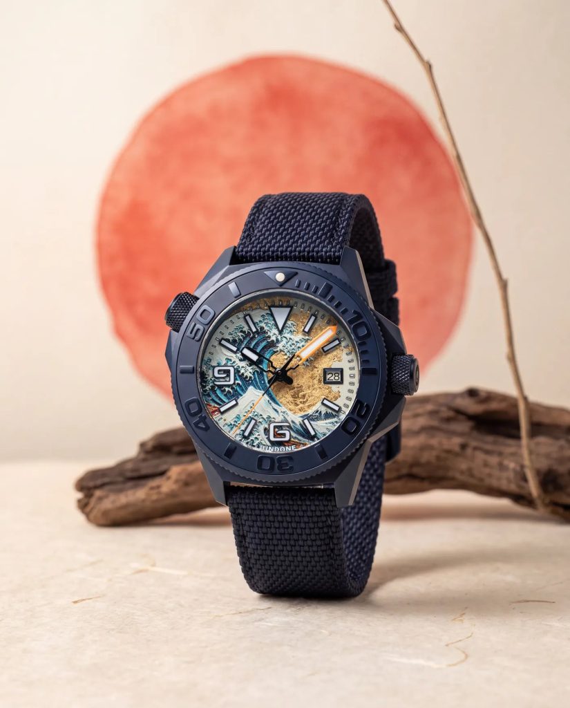 UNDONE Aquadeep The Great Wave - Visszatért és most aranyfüstre épül Hokuszai nagy hulláma Az óra papírba csomagolt fatömbön, koi pontyokkal festett vörös fal előtt