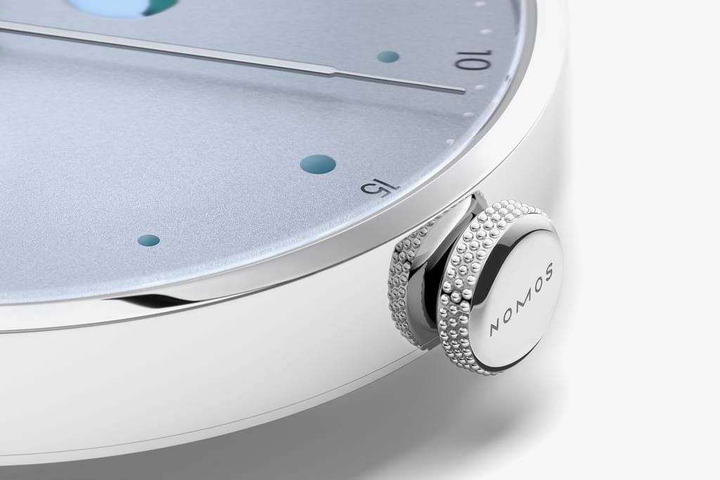 Jégkék Metro új kézi felhúzású kaliberrel: bemutatkozik a Nomos DUW 4701 Close-up of a Metro watch with ice blue dial, power reserve display, and knurled crown.