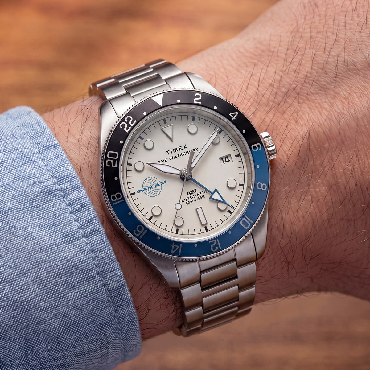 Pan Am x Timex Waterbury GMT: automata és kvarc változatban érkezik a két időzónás páros TW2Y94300 Close-up of the Pan Am x Timex Waterbury Automatic GMT watch worn with a light blue shirt.