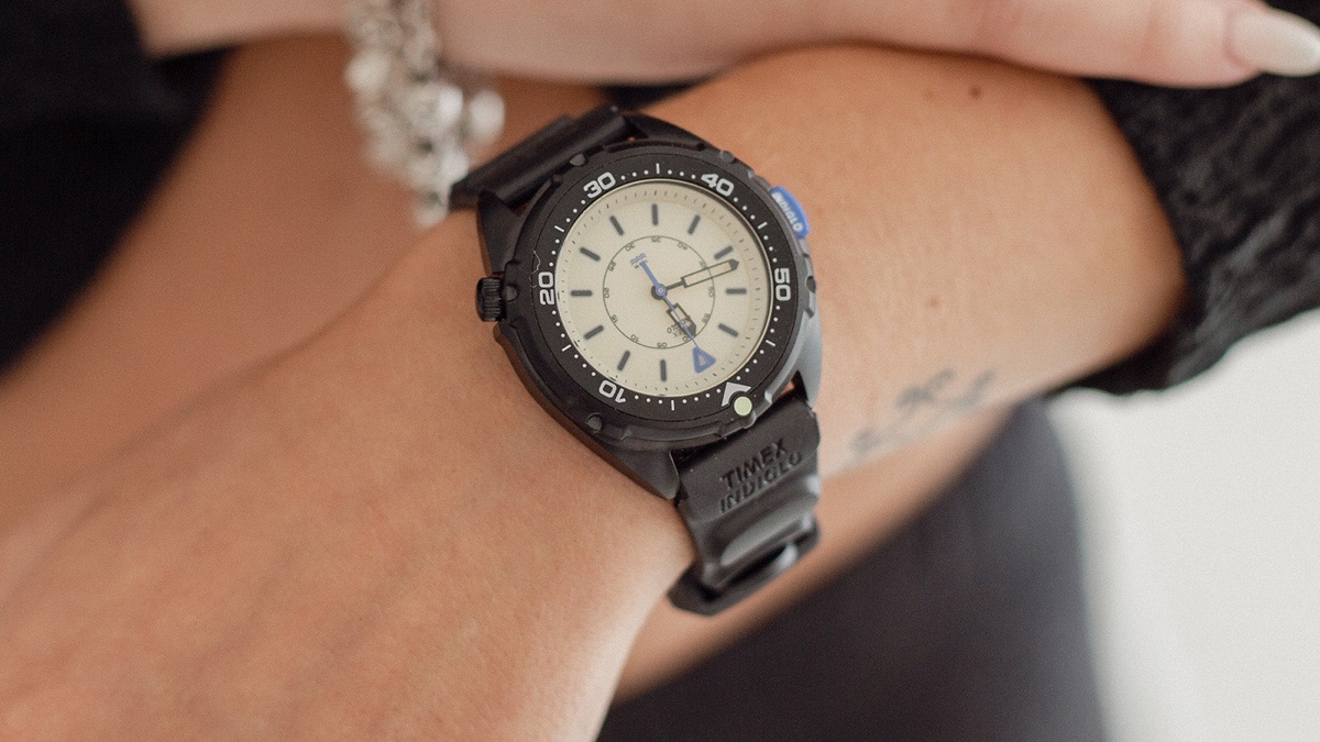 Feketébe öltözött a Timex Intrepid x Dimepiece: itt a 36 mm-es Blackout Edition TW6A19800 Timex Intrepid x Dimepiece ‘Blackout’ Edition worn on a wrist, featuring a cream dial and black strap embossed with Timex INDIGLO branding.
